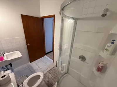 a bathroom with a shower and a toilet and a sink at Sunny Home in Sunbury