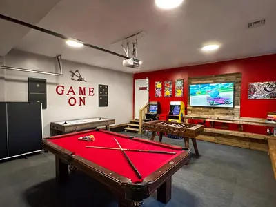 a gaming room with pool tables and a game onscreen at Rustic Poconos Ranch w Game Room in Tobyhanna