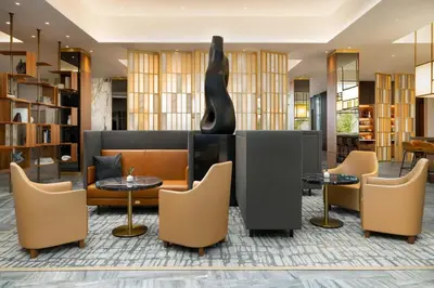 a lobby with tables and chairs and a sculpture at AC Hotel by Marriott Newtown Square in Newtown Square