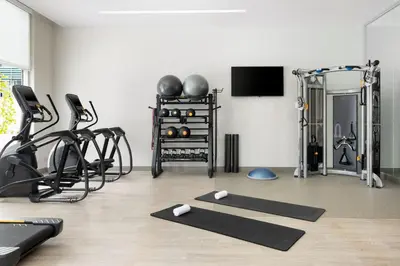 a room with a gym with several exercise equipment at AC Hotel by Marriott Newtown Square in Newtown Square