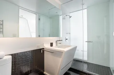 a white bathroom with a sink and a shower at Tribeca 1br w doorman gym roof deck NYC-1374 in New York
