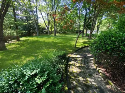 a path in a park with trees and grass at private luxe, garden, wellness home steps from Princeton in Franklin Park