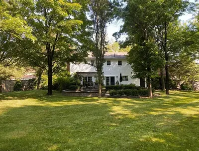 a white house with trees in the yard at private luxe, garden, wellness home steps from Princeton in Franklin Park