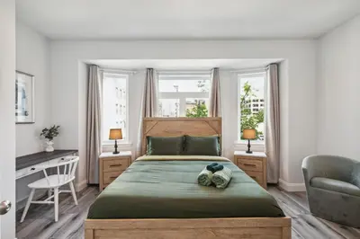 a bedroom with a bed and a desk and two windows at Stay at Luna at Convention Center in Philadelphia