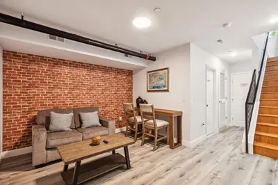a living room with a couch and a brick wall at Stay at Luna at Convention Center in Philadelphia