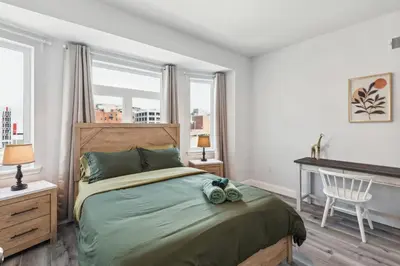 a bedroom with a bed and a desk and windows at Stay at Luna at Convention Center in Philadelphia