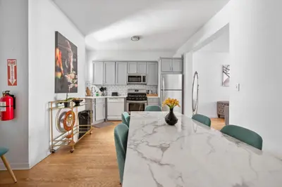a kitchen with a large marble table and green chairs at Modern Home 4BR 3BA - 20 Min to Timesquare in Jersey City