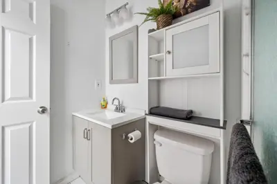 a bathroom with a toilet and a sink and a mirror at Modern Home 4BR 3BA - 20 Min to Timesquare in Jersey City