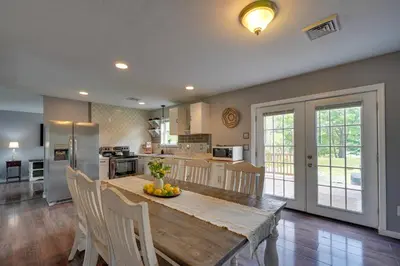 a kitchen and dining room with a wooden table and chairs at 1 Mi to Lakes Family Pocono Home with Yard and Deck! in Long Pond