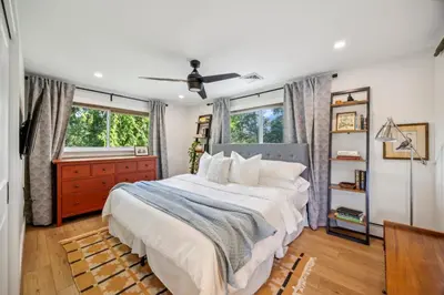 a bedroom with a large bed and two windows at Modern Mid-Century Retreat in West Chester