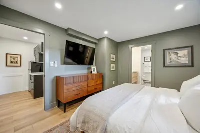 a bedroom with a large bed and a flat screen tv at Modern Mid-Century Retreat in West Chester