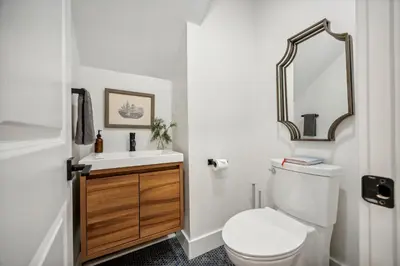 a bathroom with a toilet and a sink and a mirror at Modern Mid-Century Retreat in West Chester
