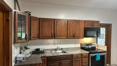 a kitchen with wooden cabinets and a sink at HARPER AVE King Bed with Private Bathroom, FREE PARKING in Irvington