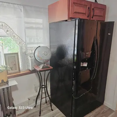 a black refrigerator in a kitchen with a stool at HARPER AVE King Bed with Private Bathroom, FREE PARKING in Irvington