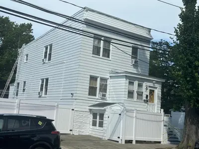 a white house with a white fence in front of it at HARPER AVE King Bed with Private Bathroom, FREE PARKING in Irvington
