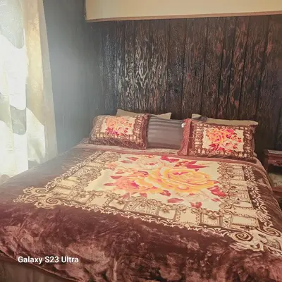 a bed with a blanket with flowers on it at HARPER AVE King Bed with Private Bathroom, FREE PARKING in Irvington