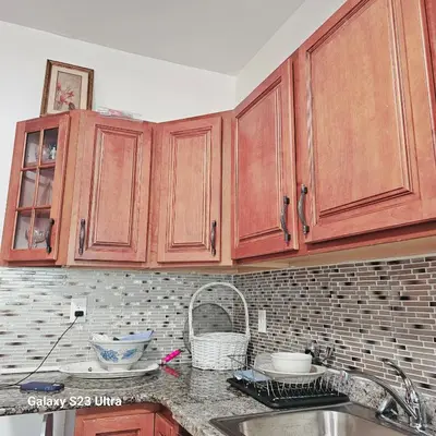 a kitchen with wooden cabinets and a sink at HARPER AVE King Bed with Private Bathroom, FREE PARKING in Irvington