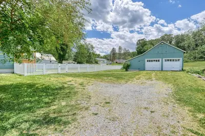 a barn with a white fence in a yard at The Farm House in Dillsburg