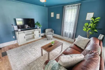 a living room with a couch and a tv at The Farm House in Dillsburg