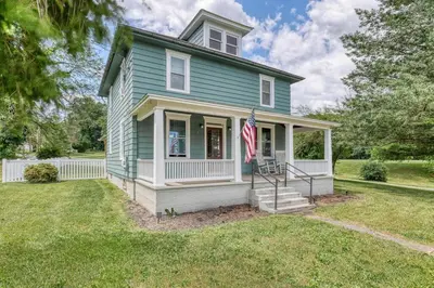 a blue house with an american flag in front of it at The Farm House in Dillsburg