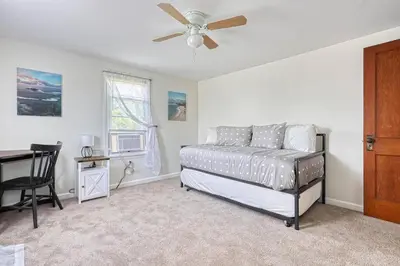 a bedroom with a bed and a desk and a ceiling fan at The Farm House in Dillsburg