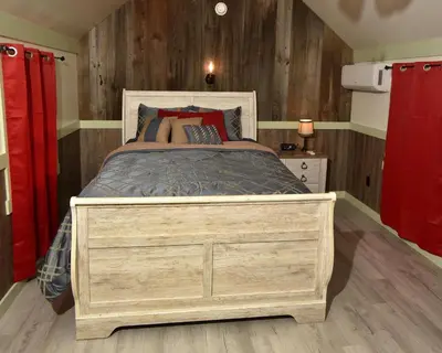 a bedroom with a large bed with a wooden wall at Penn's Creek Symphony in Spring Mills