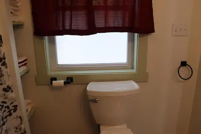 a bathroom with a toilet and a window at Penn's Creek Symphony in Spring Mills