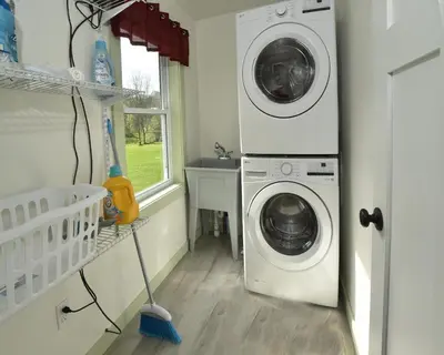 a laundry room with a washer and dryer next to a window at Penn's Creek Symphony in Spring Mills