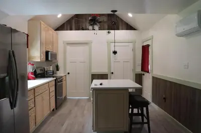 a kitchen with a refrigerator and a table in it at Penn's Creek Symphony in Spring Mills
