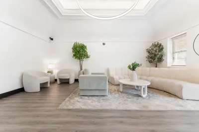 a white living room with couches and chairs at Bay Ridge ApartHotel in Brooklyn