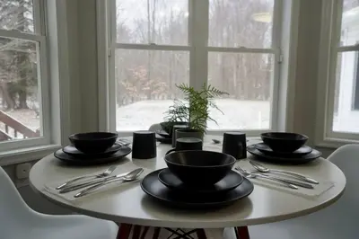 a table with black bowls and utensils on it at Perfect Vacation Home with Game Room Theater Hot Tub in Tobyhanna