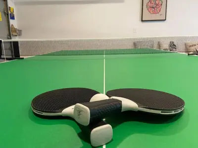a tennis racket laying on a green court at Perfect Vacation Home with Game Room Theater Hot Tub in Tobyhanna