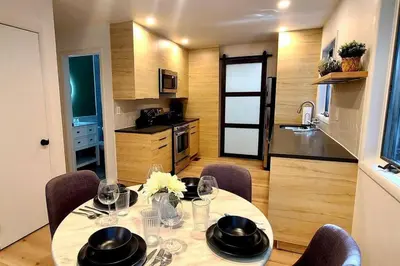 a dining room table with chairs and a kitchen at Poconos Oasis with Game Room in Pocono Summit