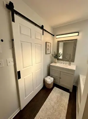 a bathroom with a white door and a sink at Cozy Modern Villa in New Castle