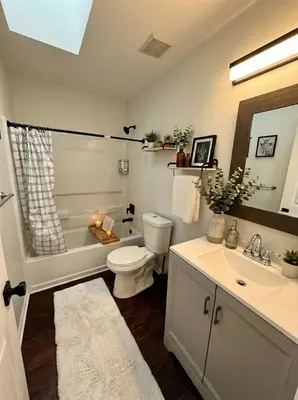 a bathroom with a toilet and a tub and a sink at Cozy Modern Villa in New Castle