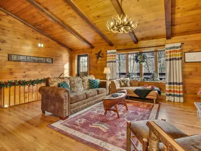 a living room with a couch and a table at WaterFront Cabin Hot Tub Kayaks Firepit Game Consoles in Tunkhannock