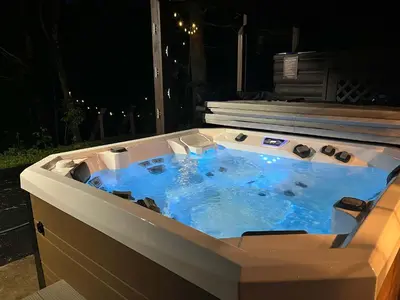 a hot tub in a backyard at night at WaterFront Cabin Hot Tub Kayaks Firepit Game Consoles in Tunkhannock