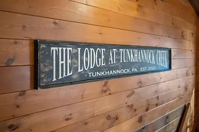 a sign on the side of a wooden wall at WaterFront Cabin Hot Tub Kayaks Firepit Game Consoles in Tunkhannock
