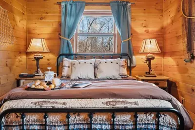 a bedroom with a bed with a tray of food on it at WaterFront Cabin Hot Tub Kayaks Firepit Game Consoles in Tunkhannock