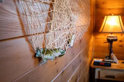 a wall with a net on it with a lamp at WaterFront Cabin Hot Tub Kayaks Firepit Game Consoles in Tunkhannock