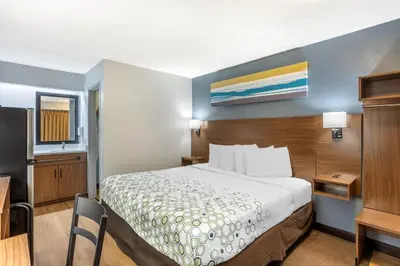 a small hotel room with a bed and a desk at HomeTowne Studios by Red Roof Danville, PA in Danville