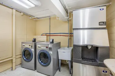 a laundry room with two washing machines and a refrigerator at HomeTowne Studios by Red Roof Danville, PA in Danville