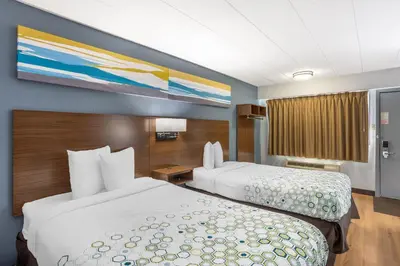 a hotel room with two beds and a painting on the wall at HomeTowne Studios by Red Roof Danville, PA in Danville