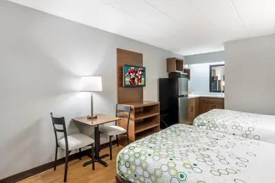 a hotel room with a bed and a desk and a kitchen at HomeTowne Studios by Red Roof Danville, PA in Danville