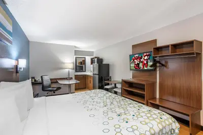 a small hotel room with a bed and a desk at HomeTowne Studios by Red Roof Danville, PA in Danville
