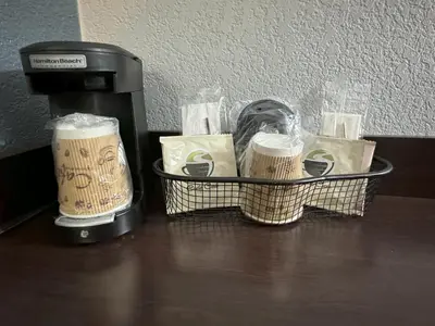 a coffee maker with two cups on a table at HomeTowne Studios by Red Roof Danville, PA in Danville