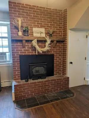 a brick fireplace in a living room at The Hidden Homestead in Lebanon