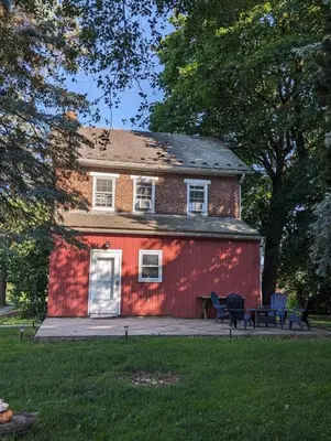 a red house with a bench in front of it at The Hidden Homestead in Lebanon
