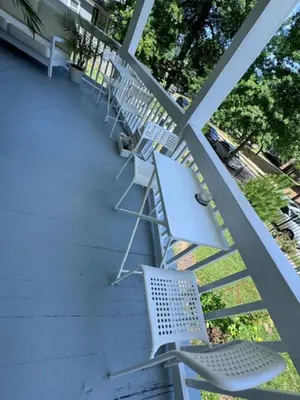 a row of white chairs sitting on a porch at Bloom Victorian Bed & Breakfast in South Orange