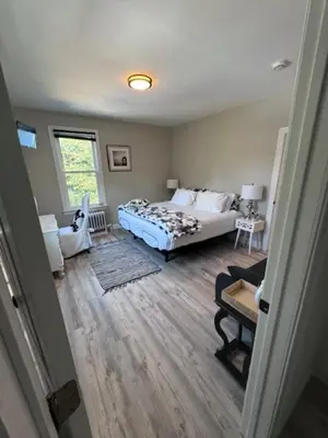 a bedroom with a bed and a living room at Bloom Victorian Bed & Breakfast in South Orange